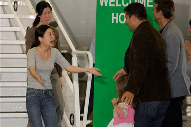 Euna Lee (in grey shirt) and Laura Ling react upon seeing their familyâ(from left) Lee's daughter Hana, Lee's husband Michael Saldate, and Ling's husband Ian Clayton